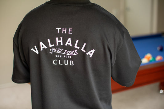 Model wearing the Valhalla Club black t-shirt by Just Roll Threads, front view, featuring breathable, moisture-wicking fabric ideal for intense BJJ training sessions, rolling, and competitions.